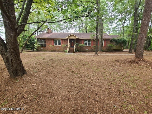 single story home featuring brick siding and a chimney