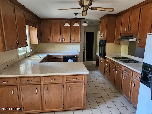 kitchen with under cabinet range hood, a peninsula, a sink, light countertops, and black appliances