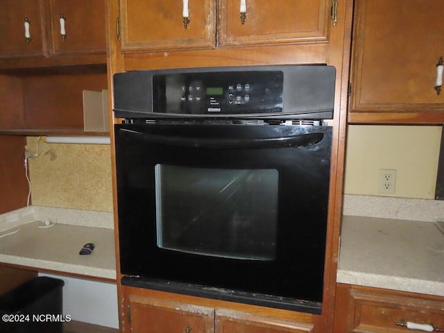 room details featuring brown cabinetry and oven