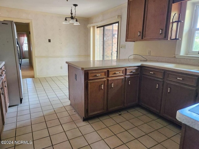 103 Creekview Ln, Washington, NC 27889 - kitchen with wallpapered walls, freestanding refrigerator, light countertops, a peninsula, and light tile patterned floors
