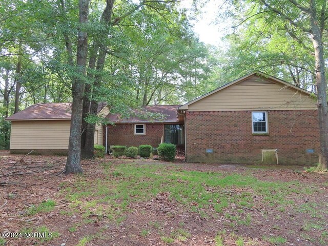 view of front facade with brick siding and crawl space