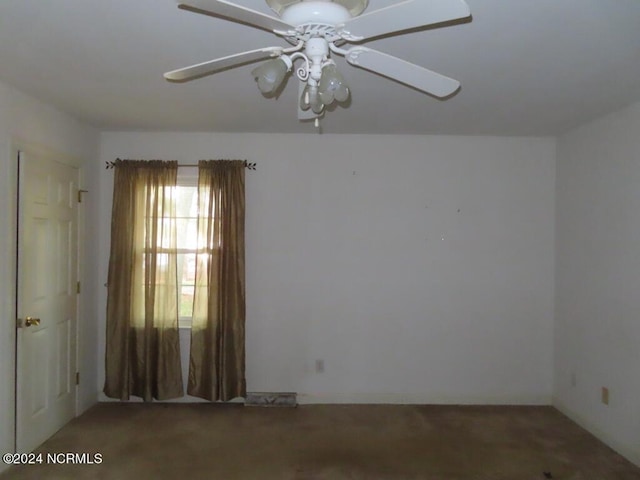 empty room with beam ceiling, a ceiling fan, wainscoting, wood walls, and light carpet