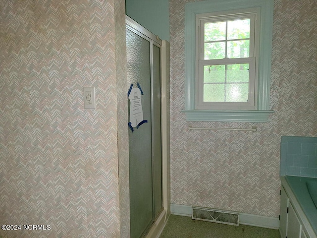 bathroom with a stall shower, visible vents, baseboards, and wallpapered walls