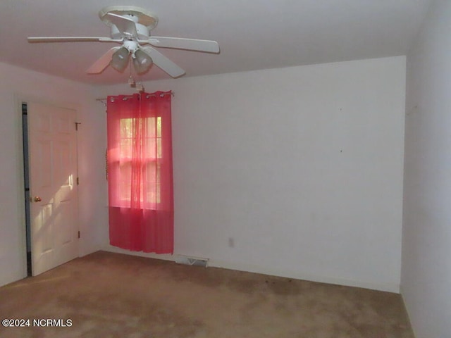 spare room with carpet floors, ceiling fan, and visible vents