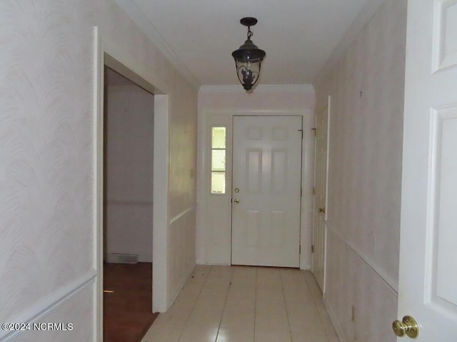 interior space with light tile patterned floors and crown molding