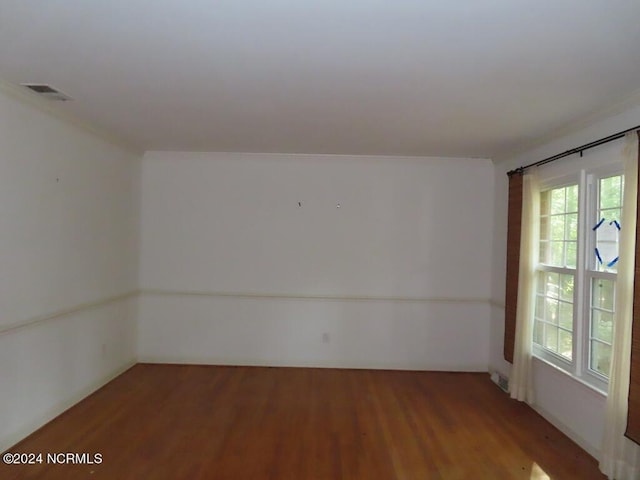 unfurnished room with visible vents and wood finished floors