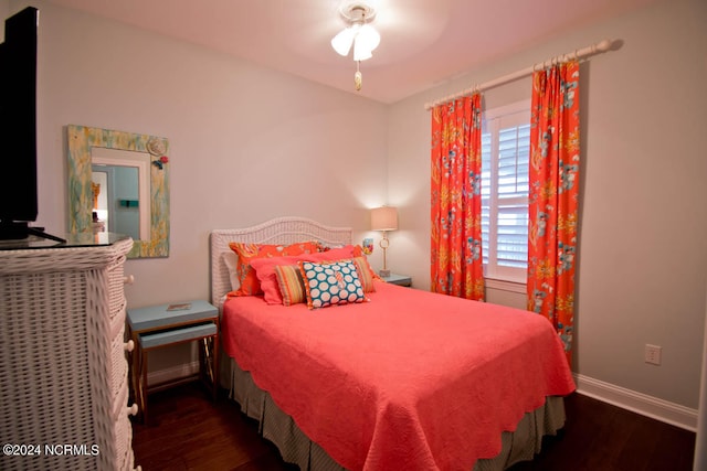 bedroom with dark hardwood / wood-style flooring and ceiling fan