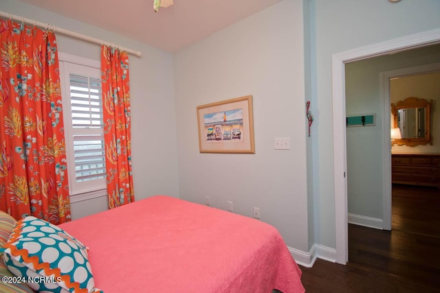 bedroom with dark wood-type flooring and baseboards