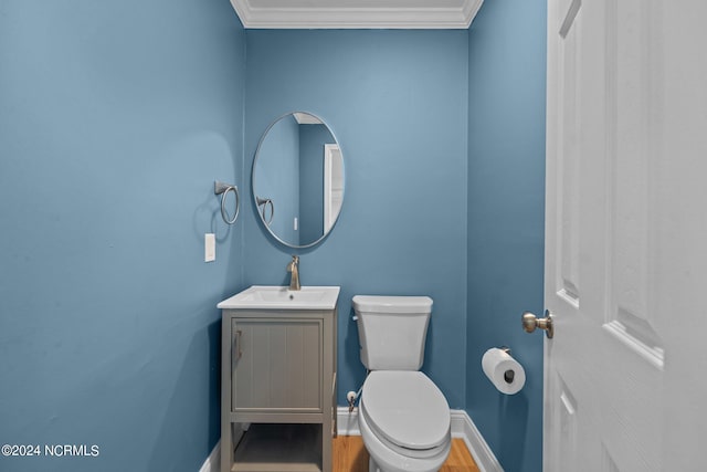 bathroom with toilet, ornamental molding, hardwood / wood-style flooring, and vanity