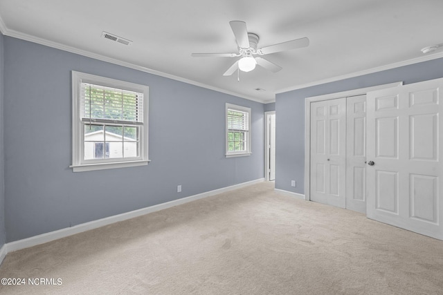 unfurnished bedroom with a closet, ceiling fan, multiple windows, and light colored carpet