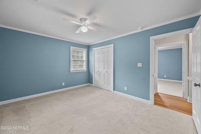 unfurnished bedroom featuring a closet, ceiling fan, ornamental molding, and light colored carpet