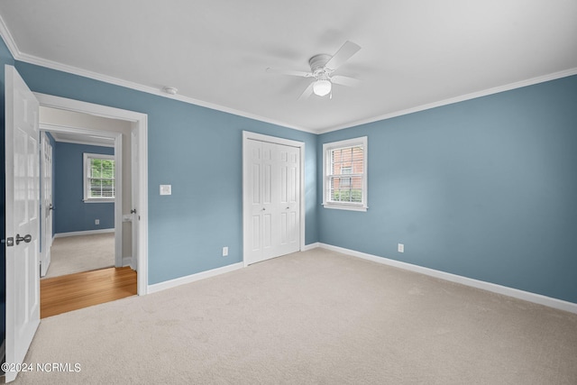 unfurnished bedroom with light carpet, multiple windows, a closet, and ceiling fan