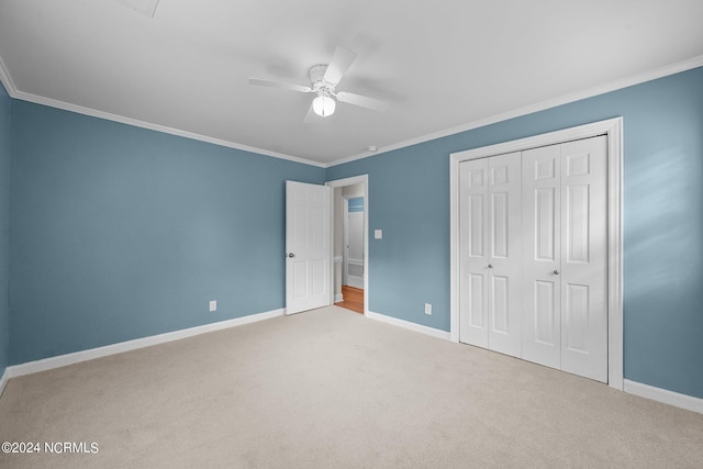 unfurnished bedroom featuring crown molding, light colored carpet, a closet, and ceiling fan