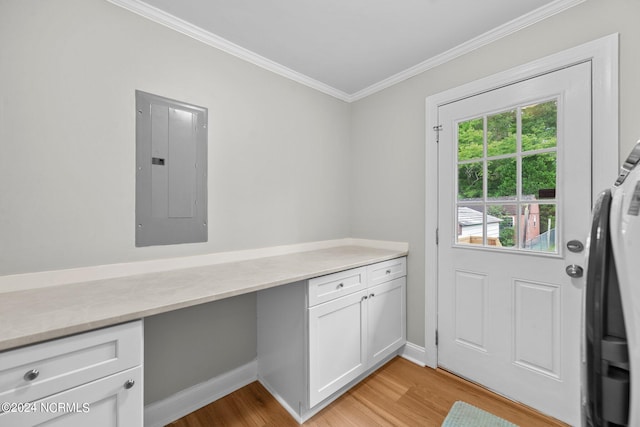 entryway featuring crown molding, electric panel, built in desk, and light wood-type flooring