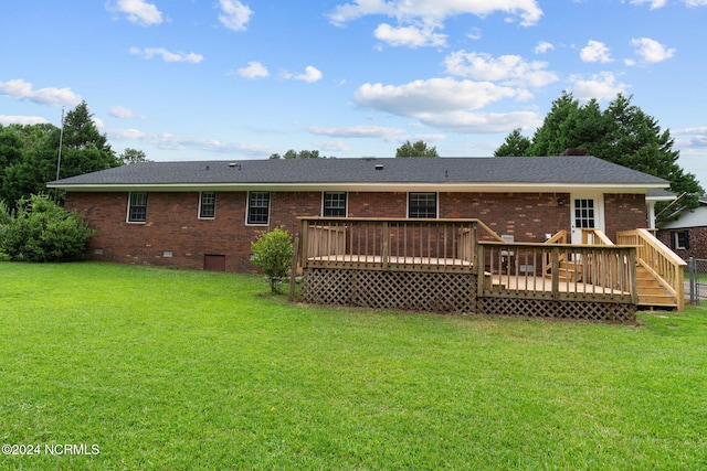 back of property featuring a wooden deck and a lawn