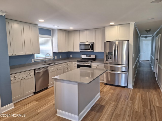 kitchen with light hardwood / wood-style floors, a center island, stainless steel appliances, and sink