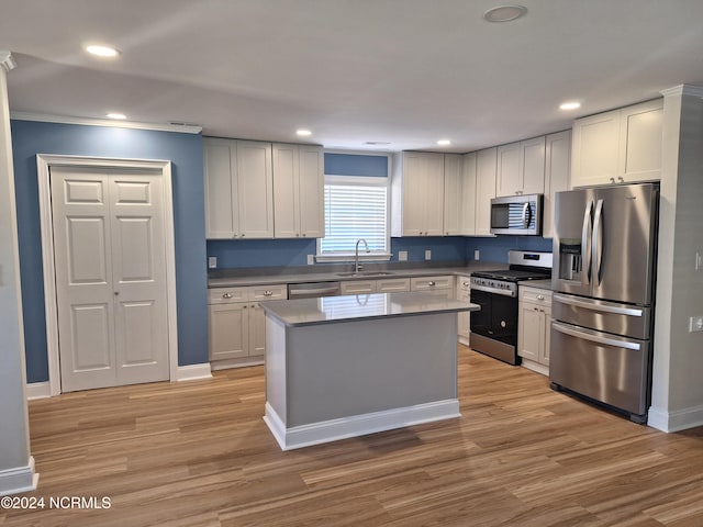 kitchen with light hardwood / wood-style floors, white cabinetry, stainless steel appliances, and sink