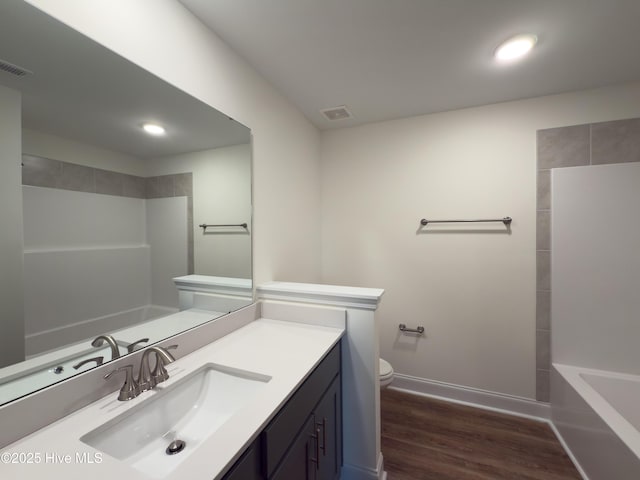 full bathroom with vanity, wood finished floors, visible vents, baseboards, and toilet