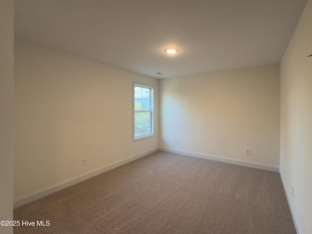 unfurnished room featuring light colored carpet and baseboards