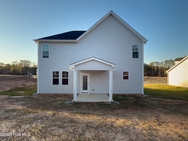 back of property with a yard and a patio area