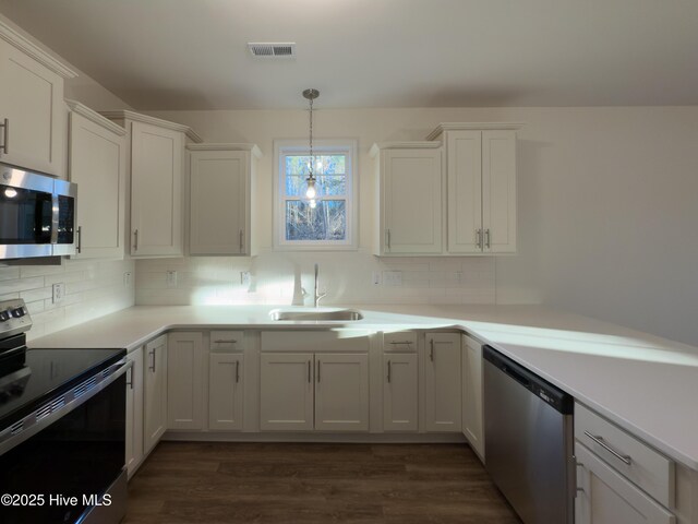 kitchen featuring white cabinets, light countertops, decorative backsplash, baseboards, and dark wood-style flooring