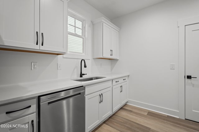 kitchen with white cabinets, dishwasher, light wood-type flooring, and sink