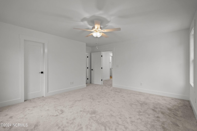 unfurnished room with ceiling fan and light colored carpet