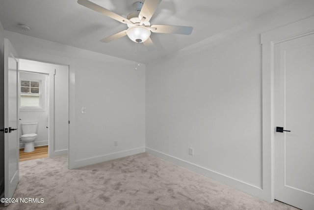 unfurnished bedroom with ceiling fan, connected bathroom, and light carpet