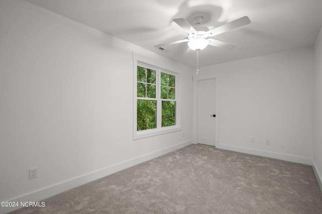 spare room with ceiling fan and carpet