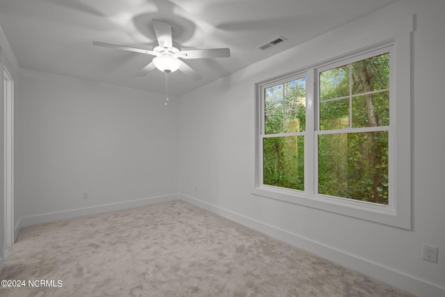 carpeted spare room with ceiling fan