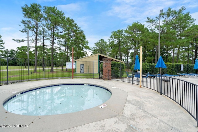 view of pool featuring a lawn