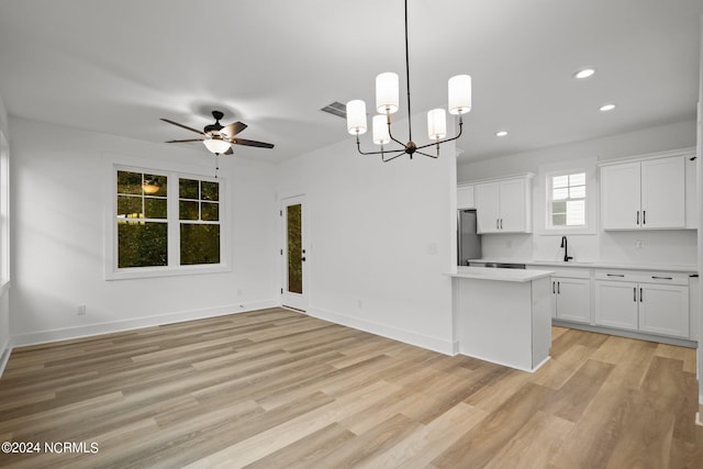 kitchen featuring light wood-type flooring, stainless steel fridge, and white cabinets