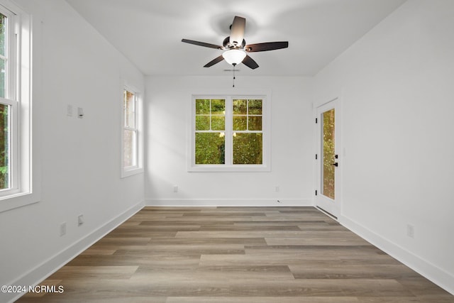 empty room with light wood-type flooring, ceiling fan, and plenty of natural light