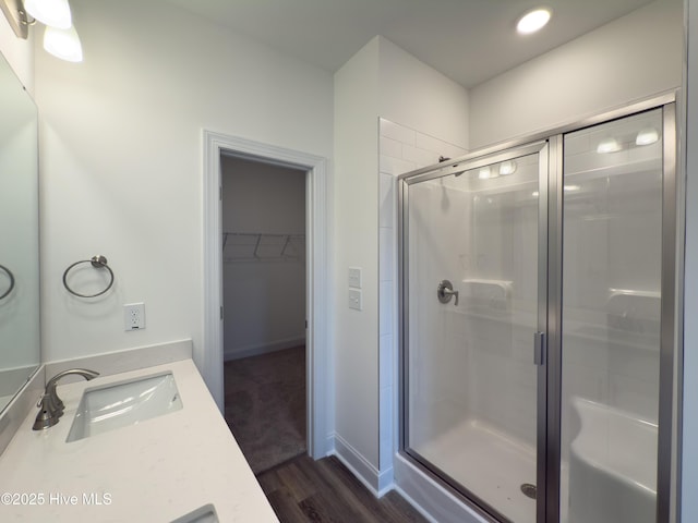 bathroom featuring walk in shower, wood-type flooring, and vanity