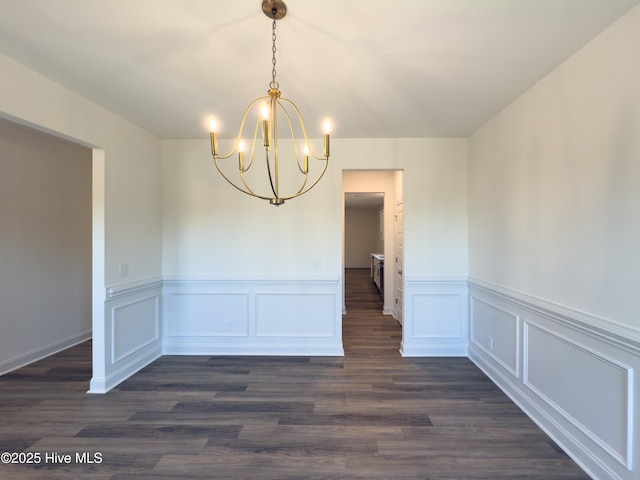 unfurnished dining area featuring a notable chandelier and dark hardwood / wood-style floors