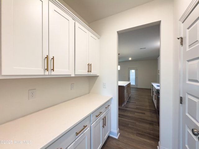 bar with white cabinetry and dark hardwood / wood-style flooring