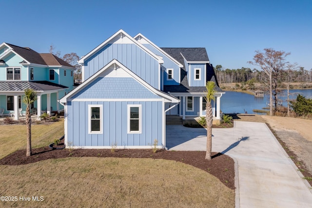 13 E Cannon Cv, Hampstead, NC 28443 - view of front facade with board and batten siding, a water view, a front lawn, and concrete driveway