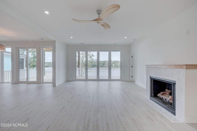 unfurnished living room featuring ceiling fan and light hardwood / wood-style floors