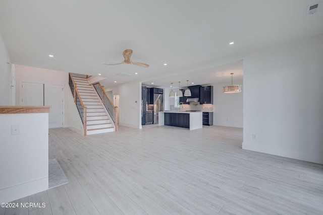 unfurnished living room featuring light hardwood / wood-style flooring and ceiling fan