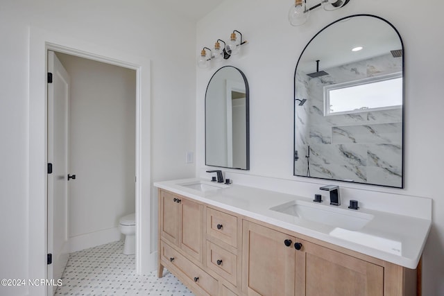 bathroom featuring tiled shower, vanity, and toilet