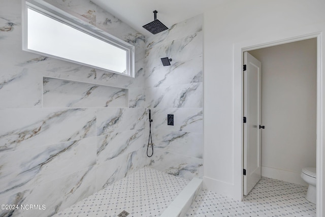 bathroom featuring toilet and a tile shower