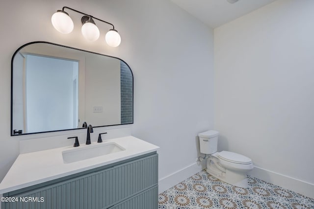 bathroom featuring tile patterned flooring, vanity, and toilet