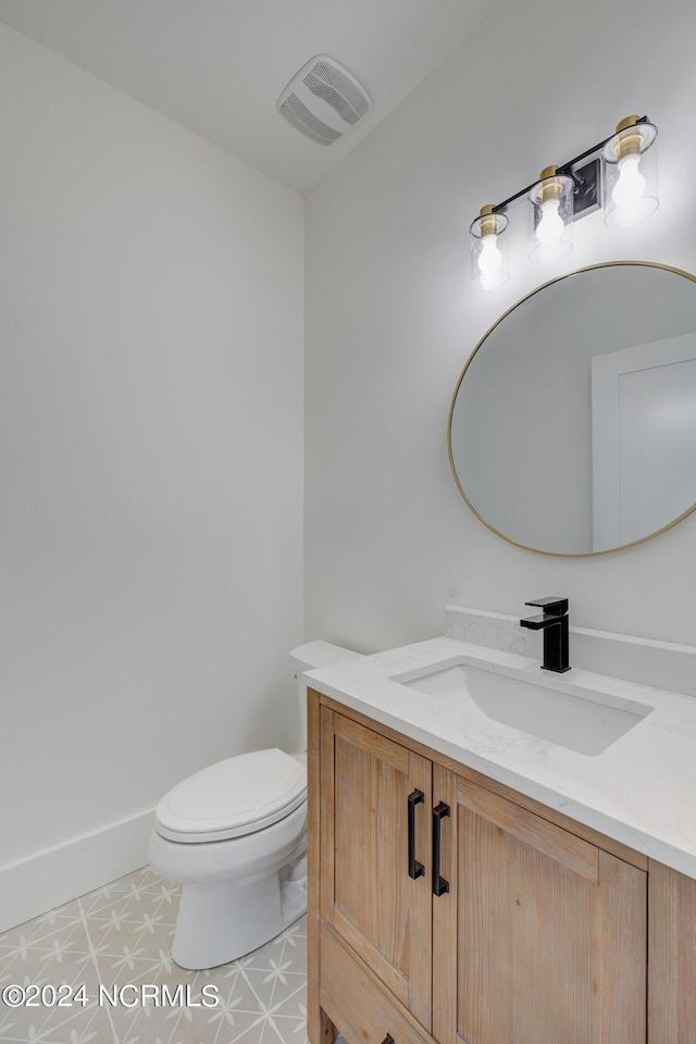 bathroom featuring tile patterned flooring, vanity, and toilet