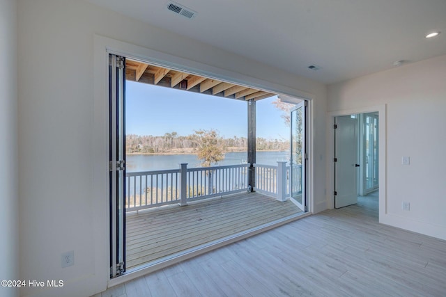 interior space with light wood-type flooring and a water view