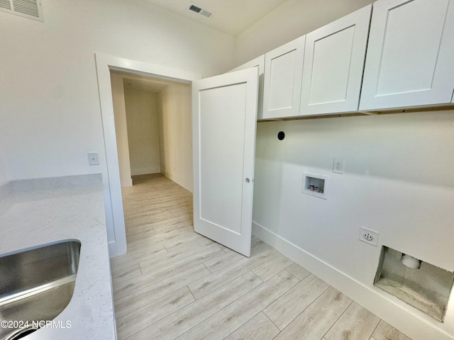 laundry area with cabinets, washer hookup, light hardwood / wood-style floors, and hookup for an electric dryer