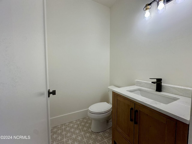 bathroom featuring tile patterned flooring, vanity, and toilet