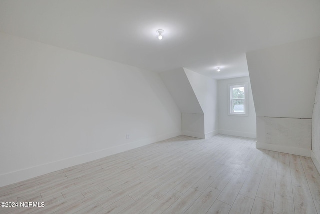 additional living space with light hardwood / wood-style flooring