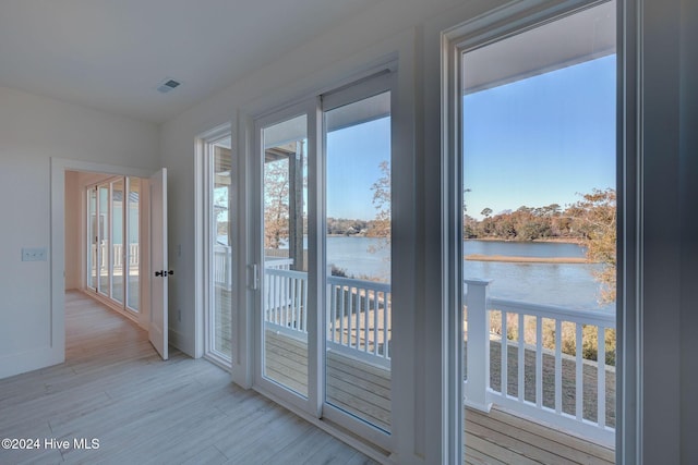 doorway featuring light wood-type flooring and a water view