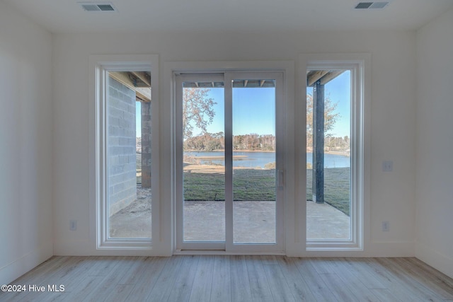 entryway featuring a water view and light wood-type flooring