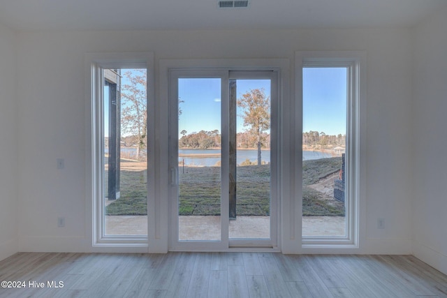 13 E Cannon Cv, Hampstead, NC 28443 - doorway to outside featuring a water view, baseboards, light wood-type flooring, and visible vents